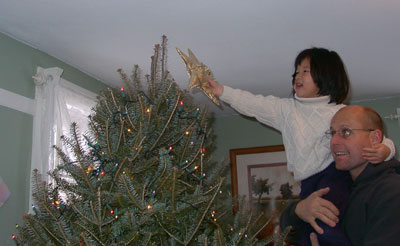 Allie and Doug put the star on the tree. Photo by Bet